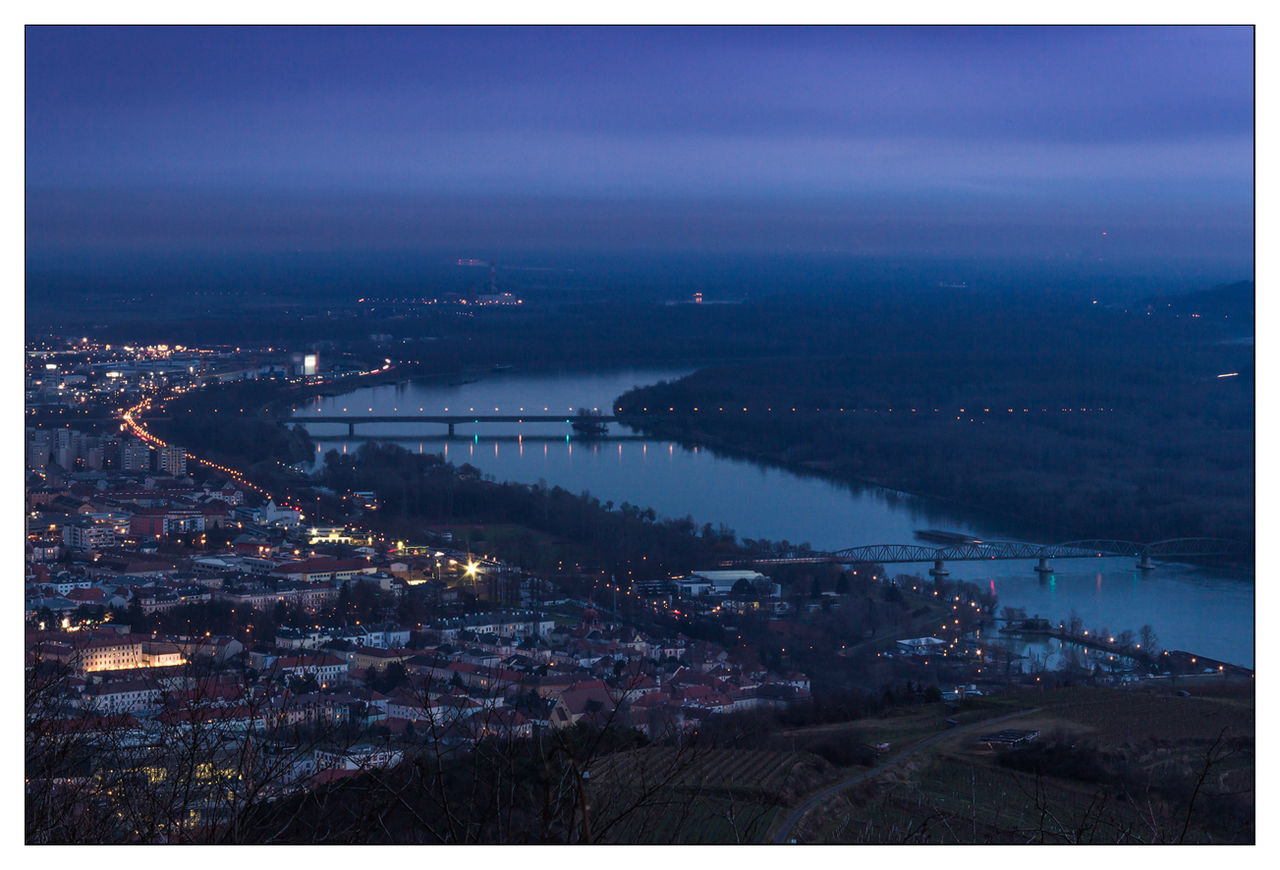 AERIAL VIEW OF ILLUMINATED CITYSCAPE AT NIGHT