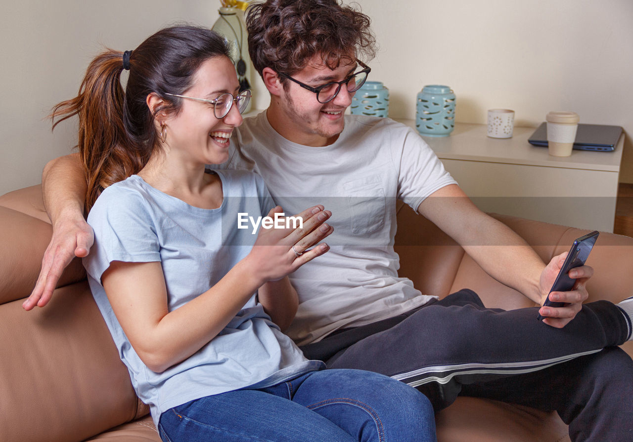 Couple talking on video call while sitting at home