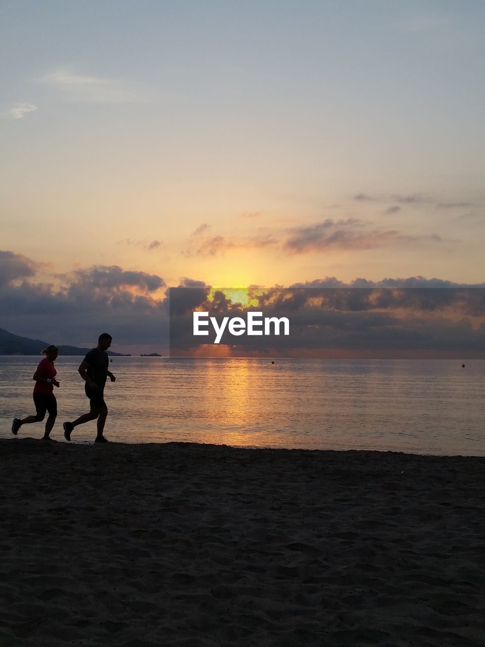 Scenic view of beach against cloudy sky