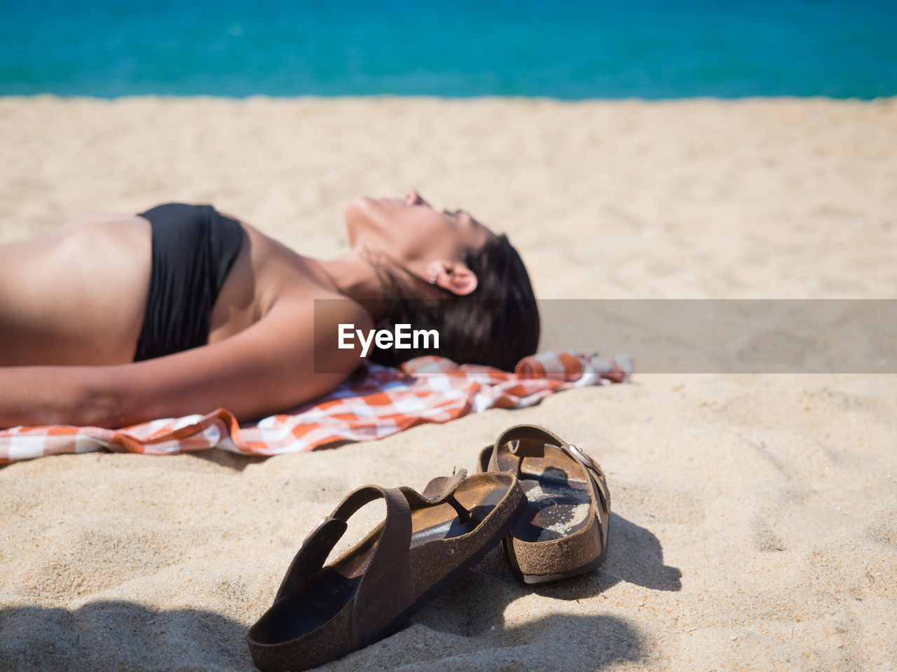 Man lying down on sand at beach