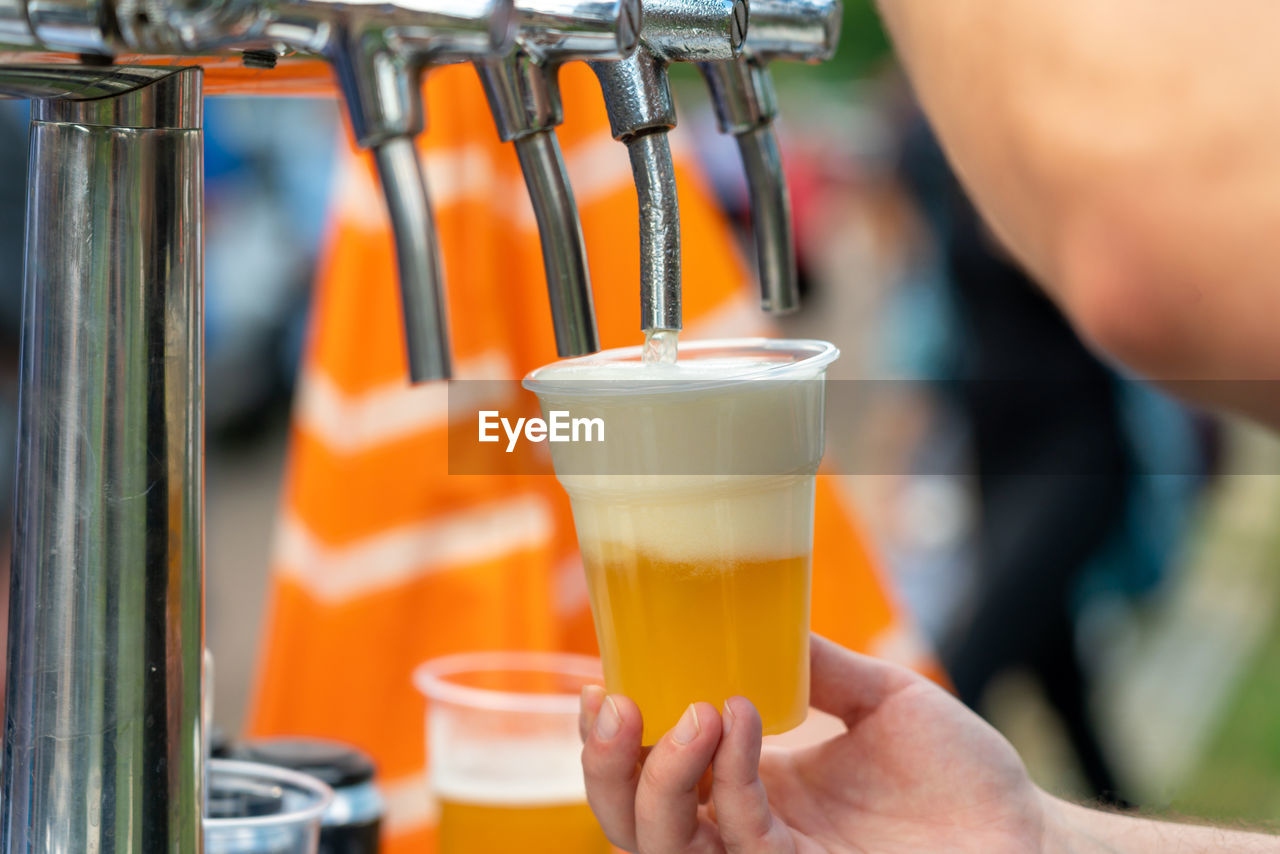 cropped hand of man holding beer