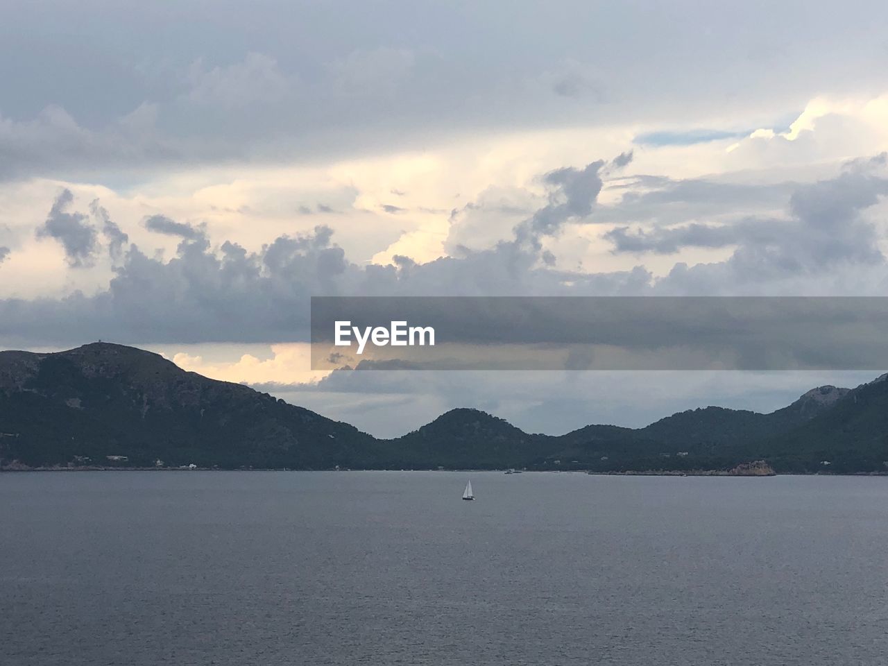 SCENIC VIEW OF SEA BY MOUNTAIN AGAINST SKY