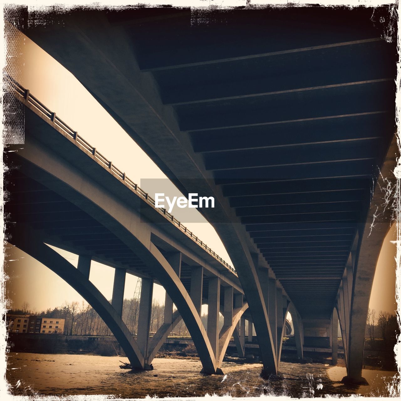 LOW ANGLE VIEW OF BRIDGE OVER RIVER AGAINST THE SKY