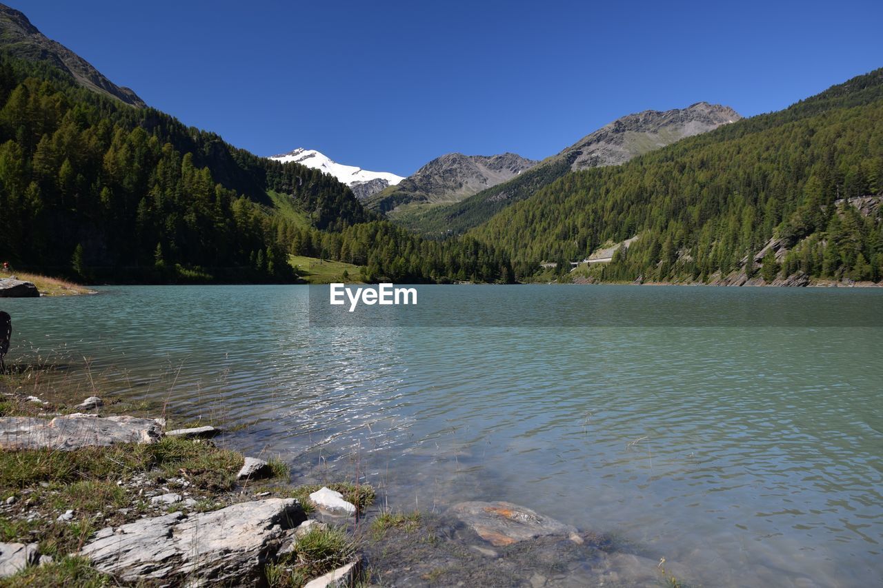 Scenic view of lake and mountains against clear sky