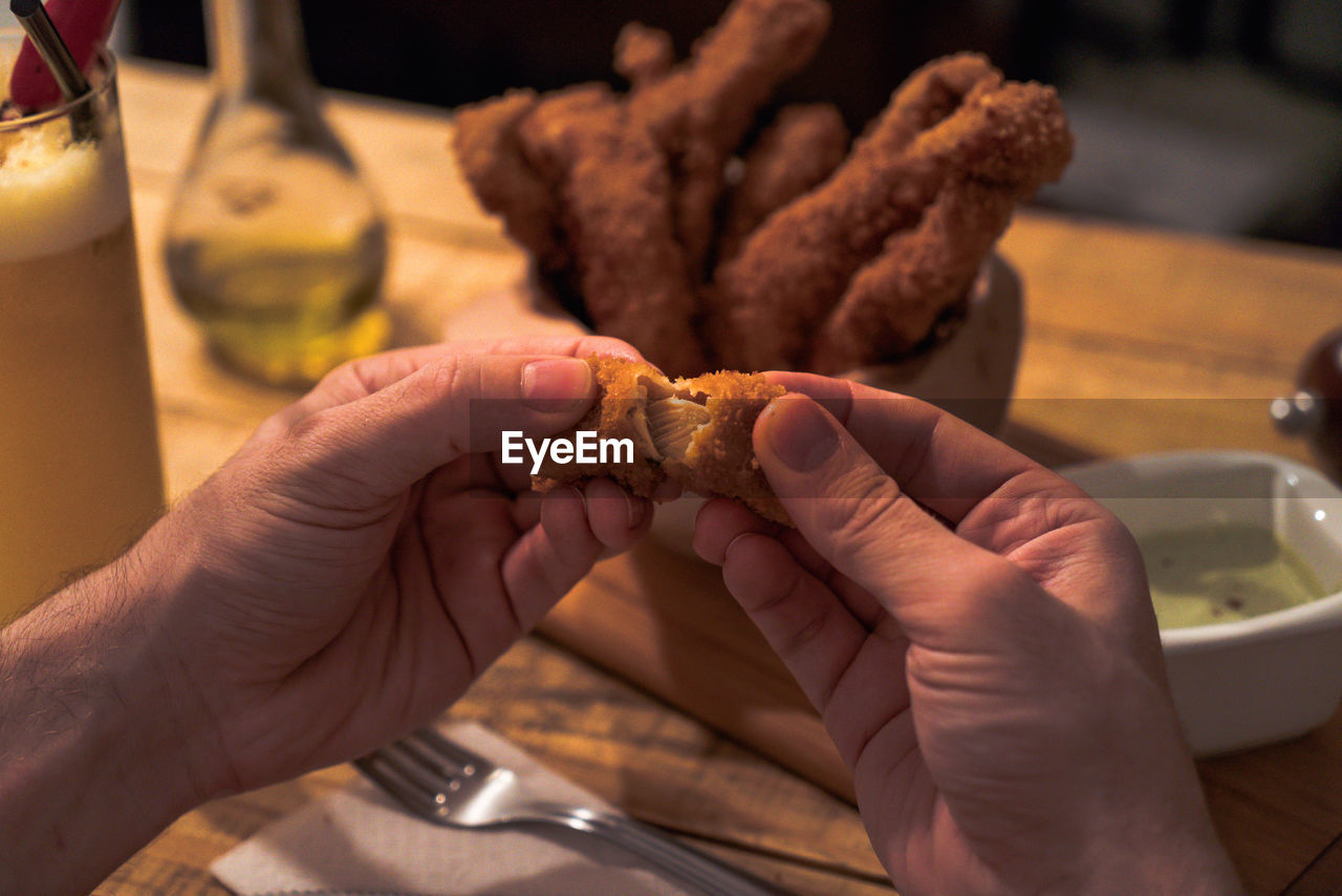 CLOSE-UP OF MAN HOLDING FOOD