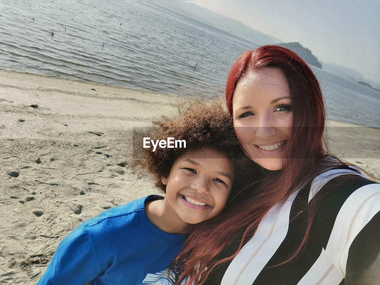 PORTRAIT OF HAPPY WOMAN ON BEACH