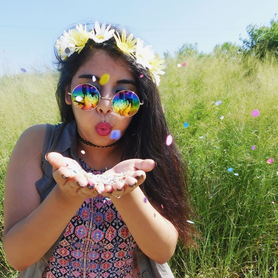 Portrait of young woman blowing confetti