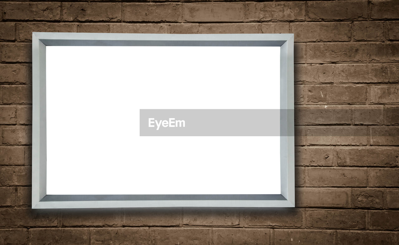 Empty frame against brick wall