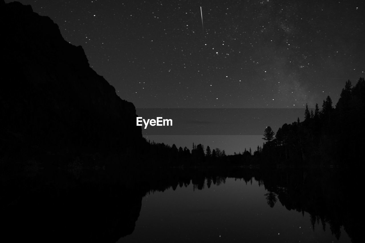 Scenic view of lake against sky at night