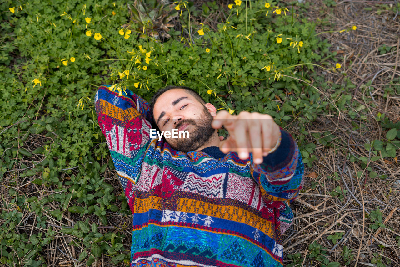 Moroccan man laying on the ground and holding his hand up to the camera