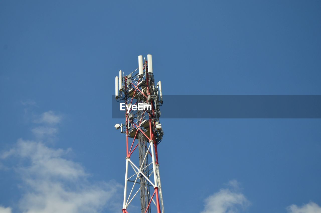 Low angle view of communications tower against blue sky