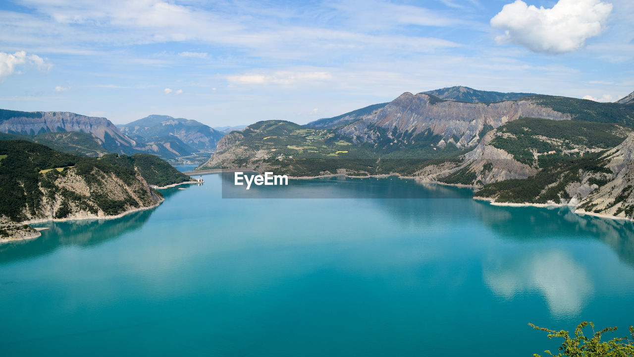 Scenic view of lake by mountains against sky