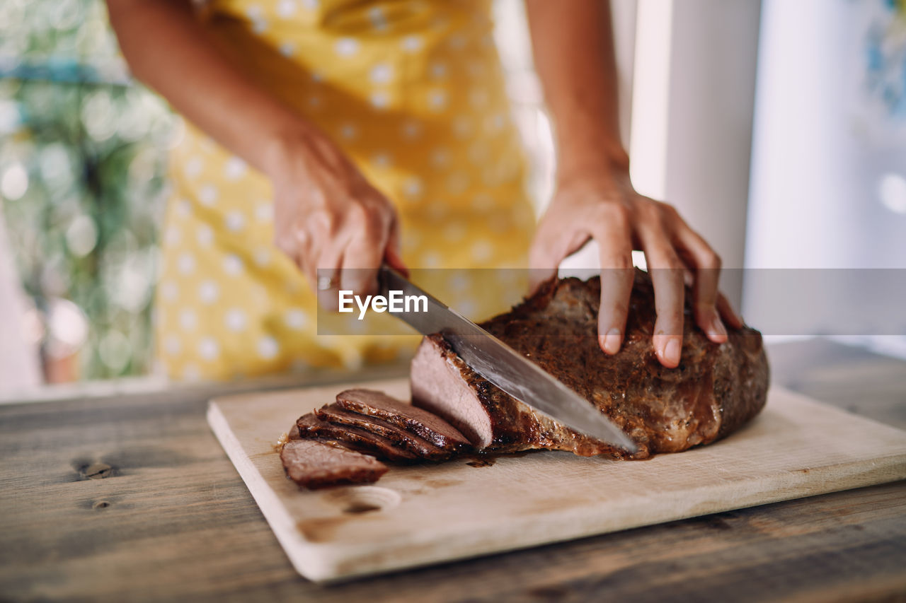 midsection of man preparing food on cutting board