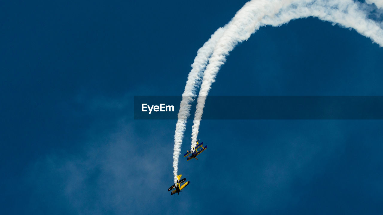 LOW ANGLE VIEW OF AIRSHOW AGAINST SKY