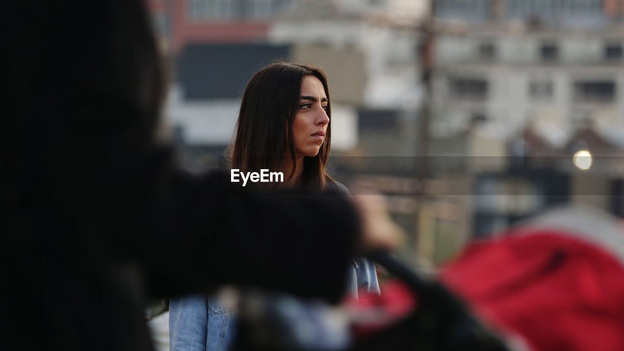 CLOSE-UP OF YOUNG WOMAN WEARING EYEGLASSES