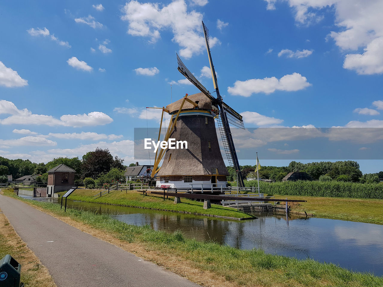 TRADITIONAL WINDMILL BY PLANTS AGAINST SKY