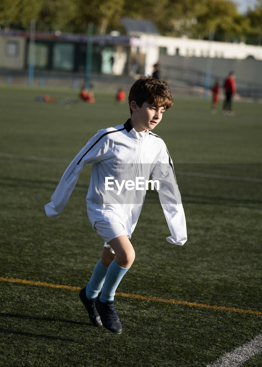 Kid player exercising before match on soccer field. kids soccer football concept