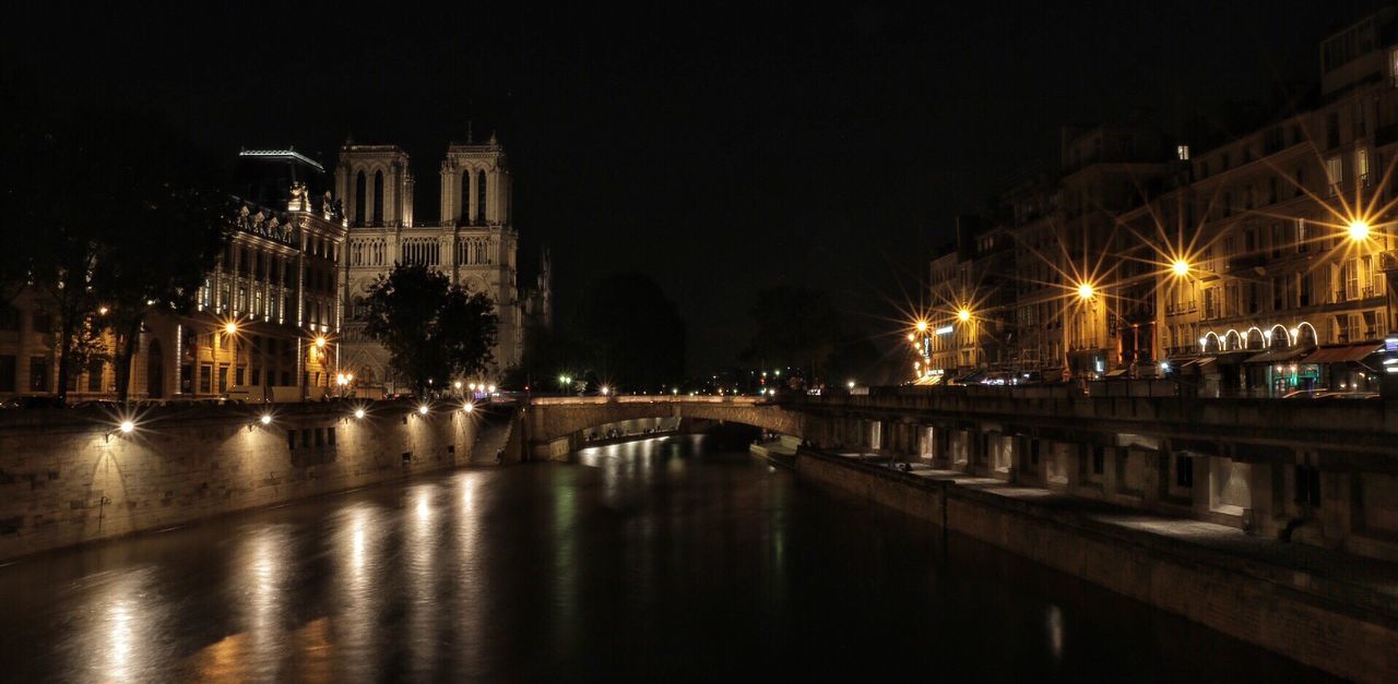 REFLECTION OF ILLUMINATED BUILDINGS IN WATER AT NIGHT