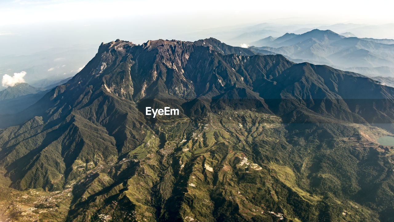 Scenic view of mountain range against cloudy sky