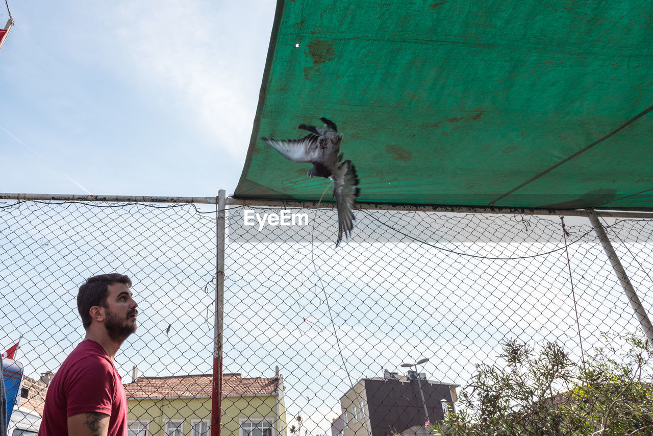 LOW ANGLE VIEW OF MAN AGAINST SKY