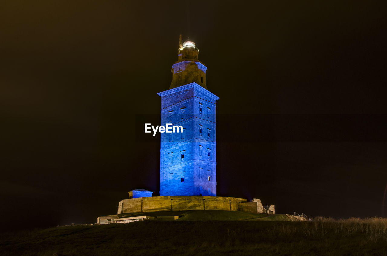 Low angle view of illuminated building against sky at night