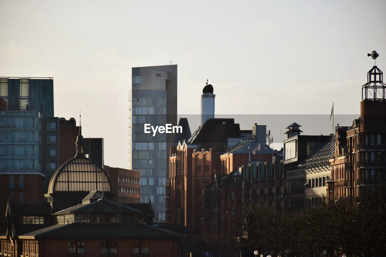 Buildings in city against sky during sunset