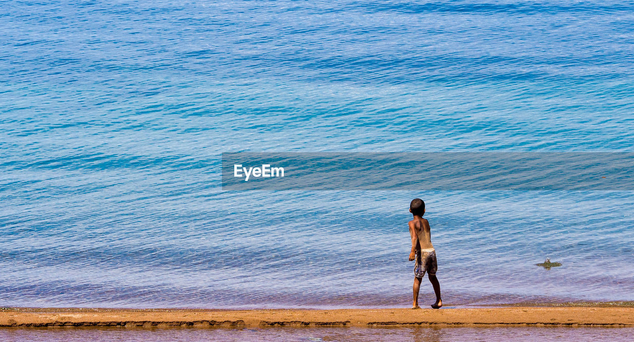 WOMAN STANDING ON BEACH