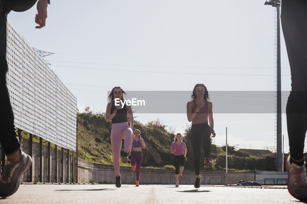 Female athletes running on sunny day