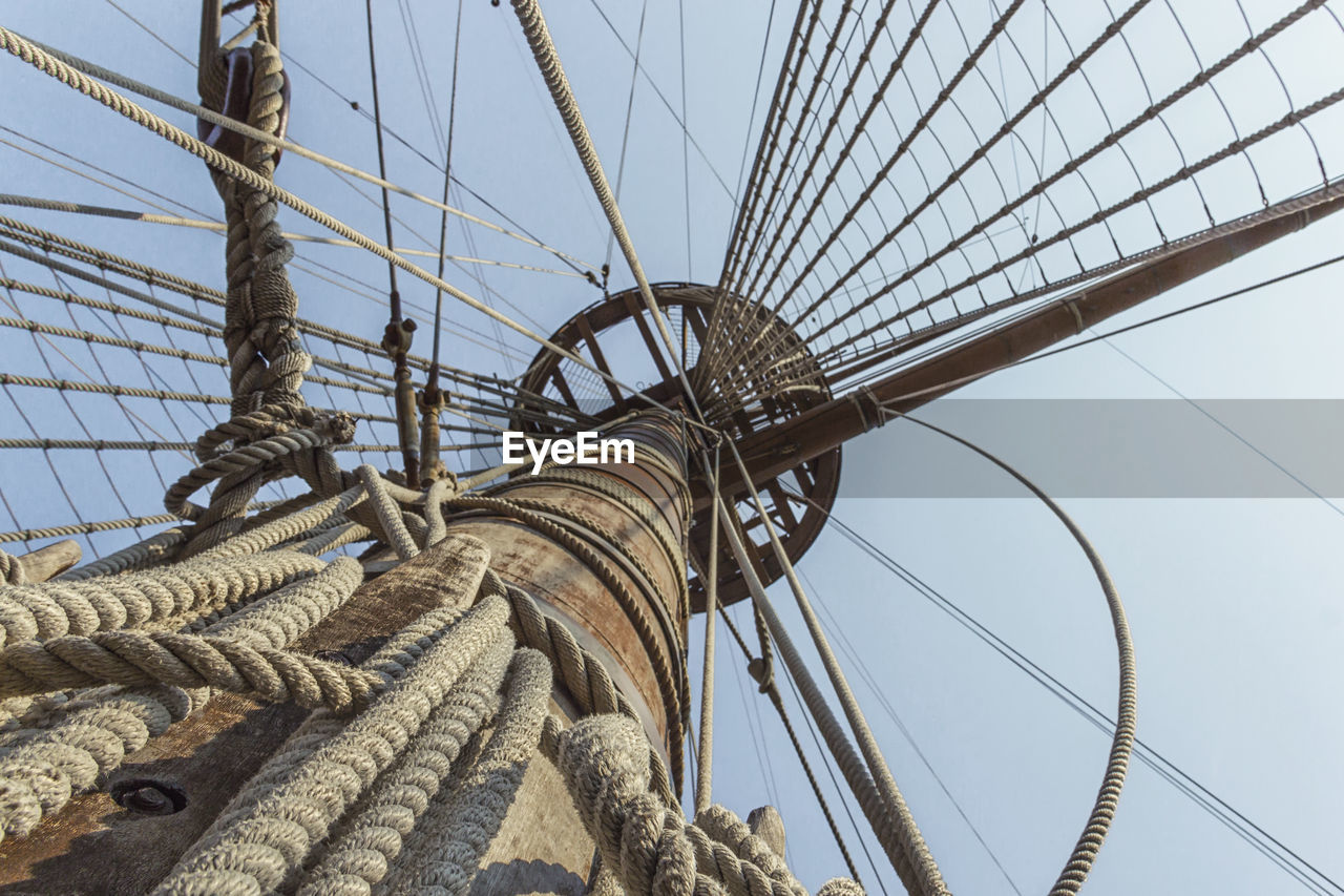Suspension bridge on galleon with wood and rope against sky