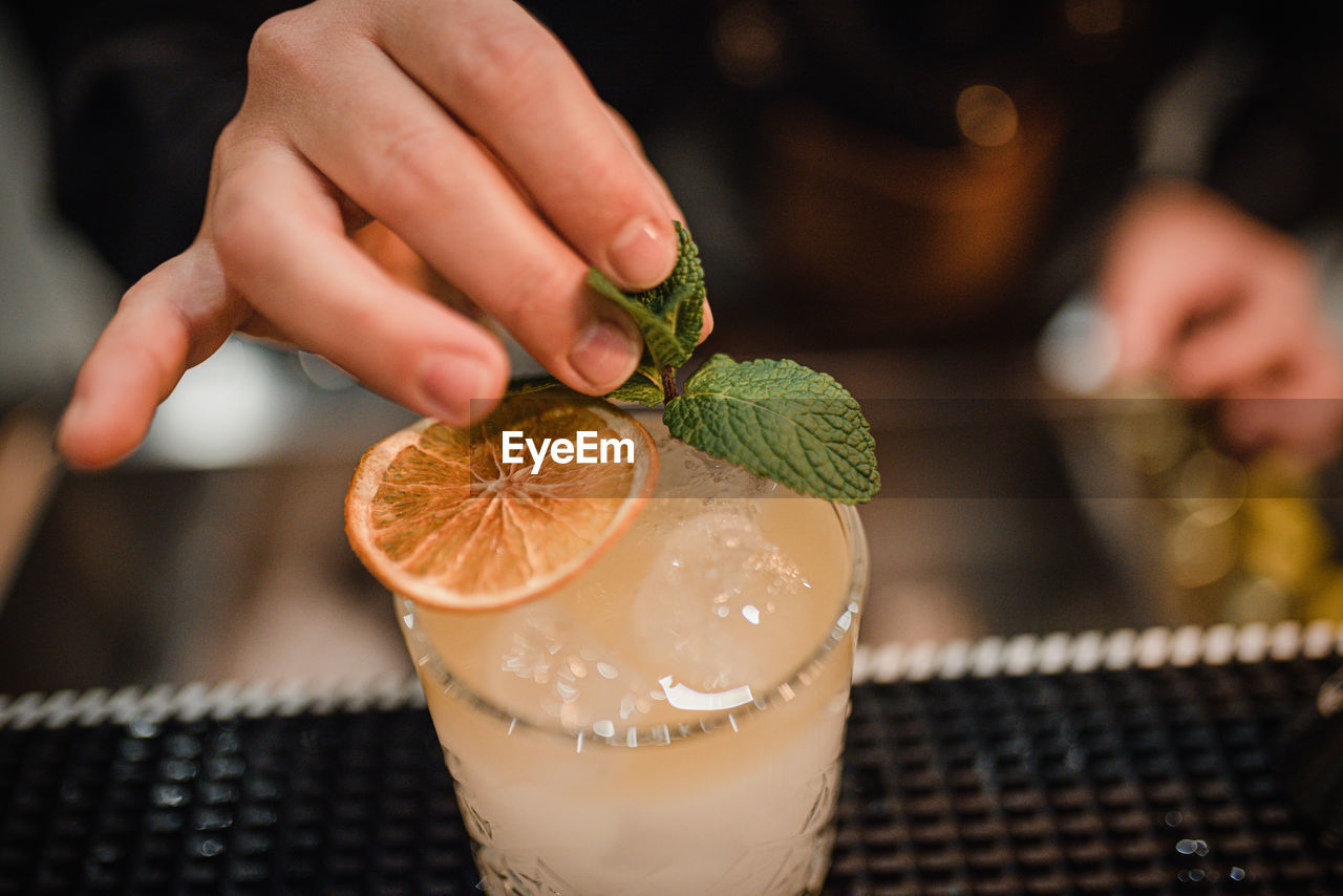 Close-up of hand holding drink on table