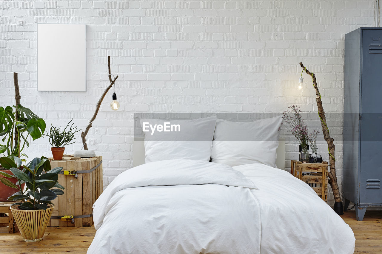 WHITE VASE ON BED AGAINST WALL