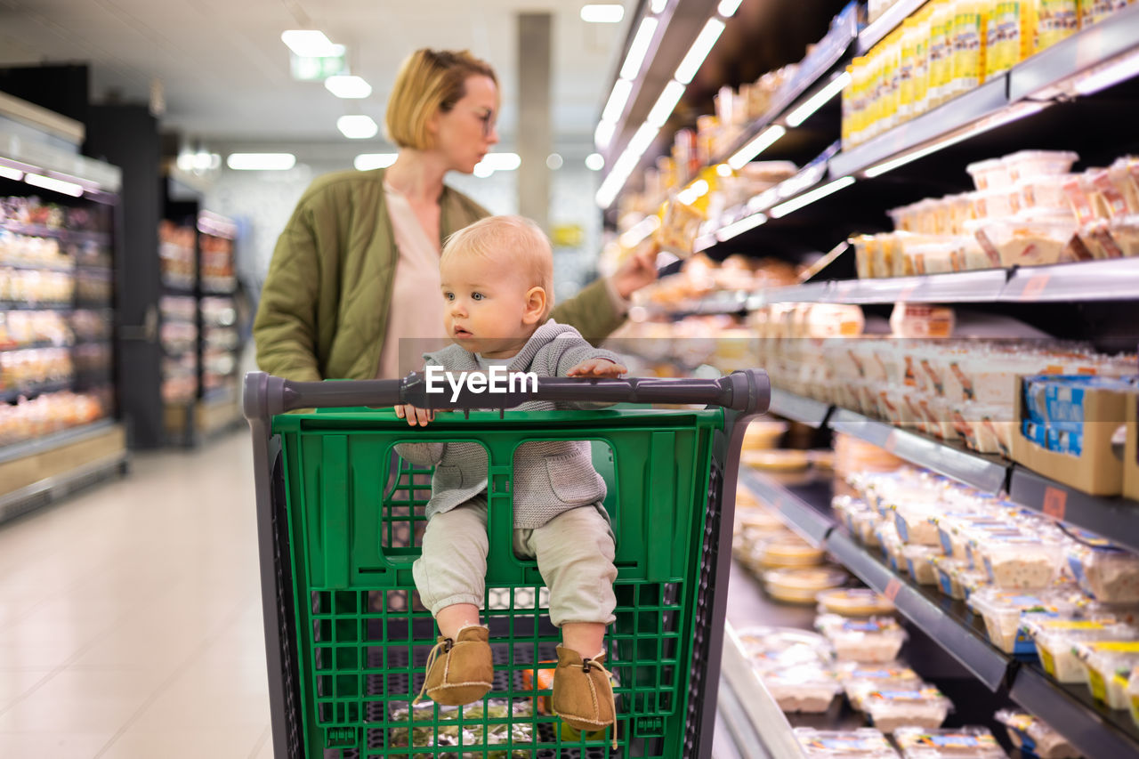 rear view of young woman standing in supermarket