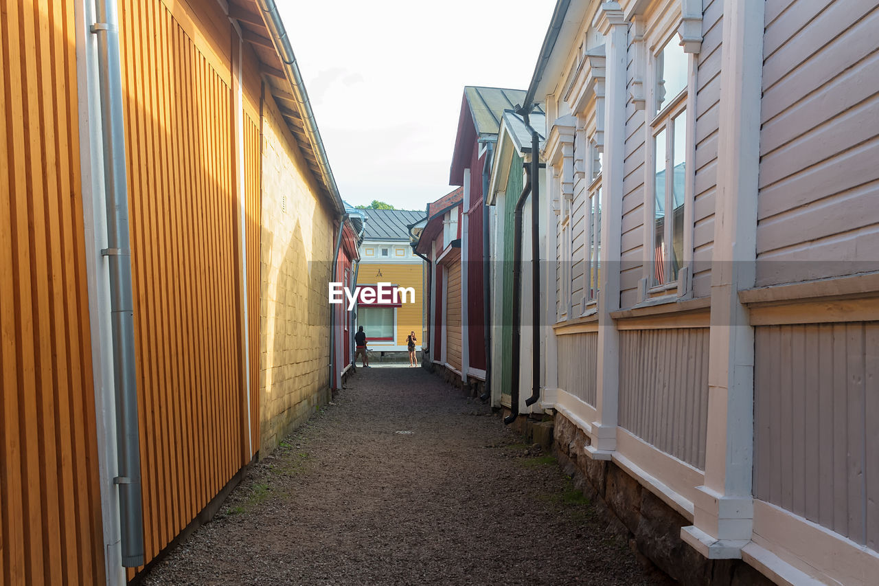 FOOTPATH AMIDST BUILDINGS AGAINST SKY