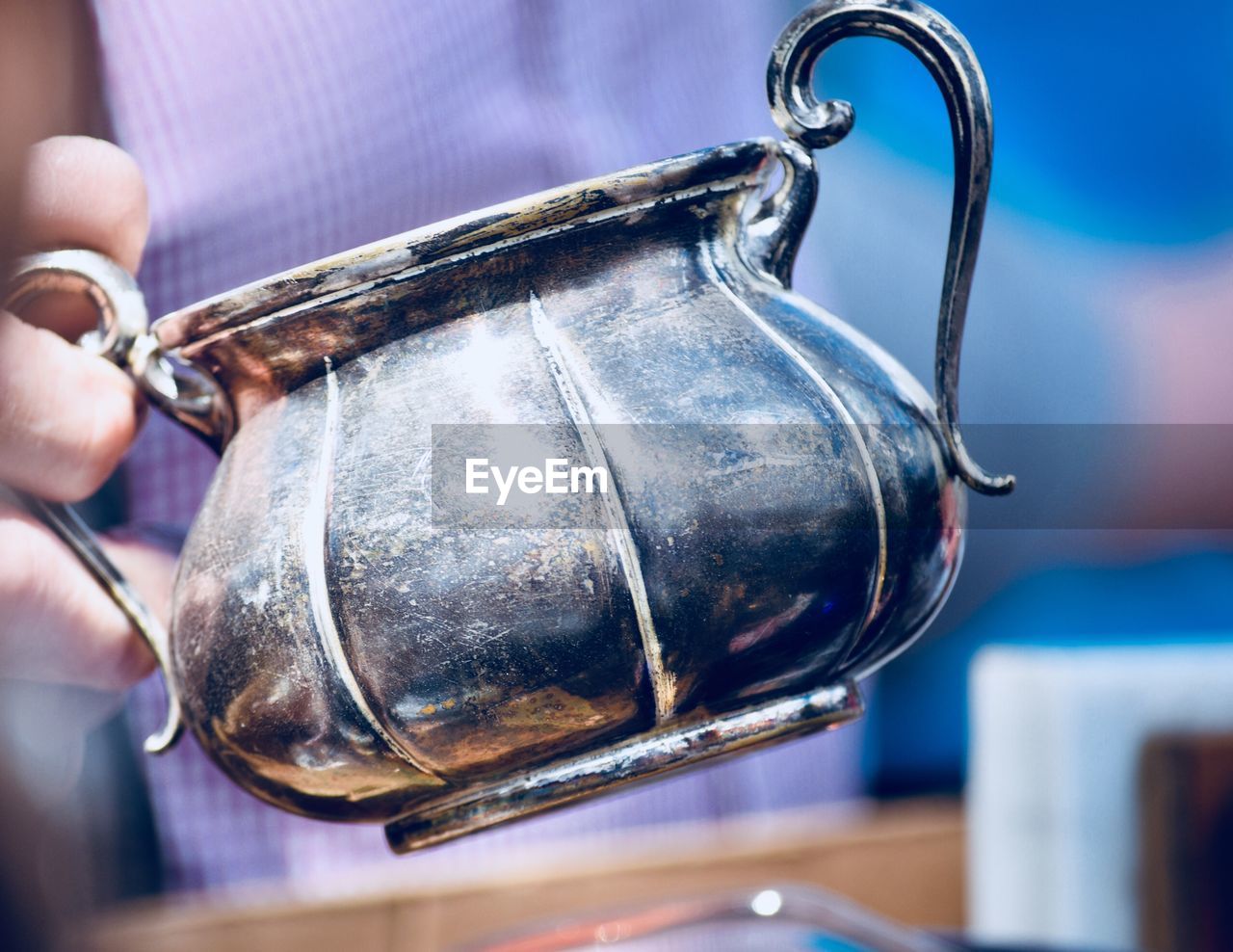 Close-up of human hand holding metallic container