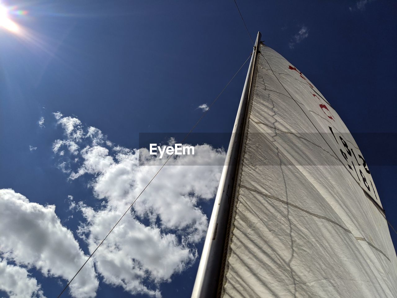 LOW ANGLE VIEW OF SAILBOAT AGAINST CLOUDY SKY