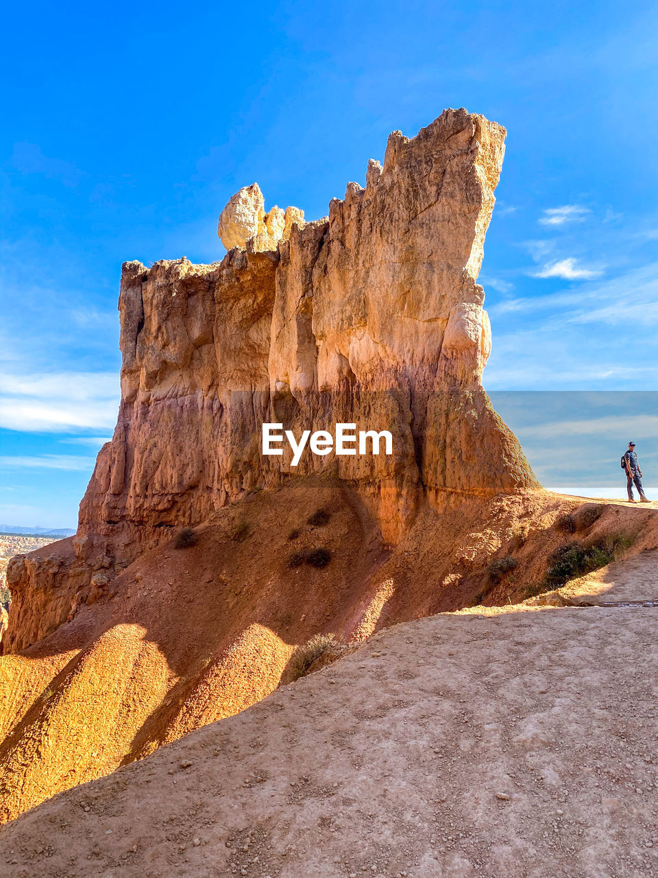 Full length of man standing by rock formation against sky