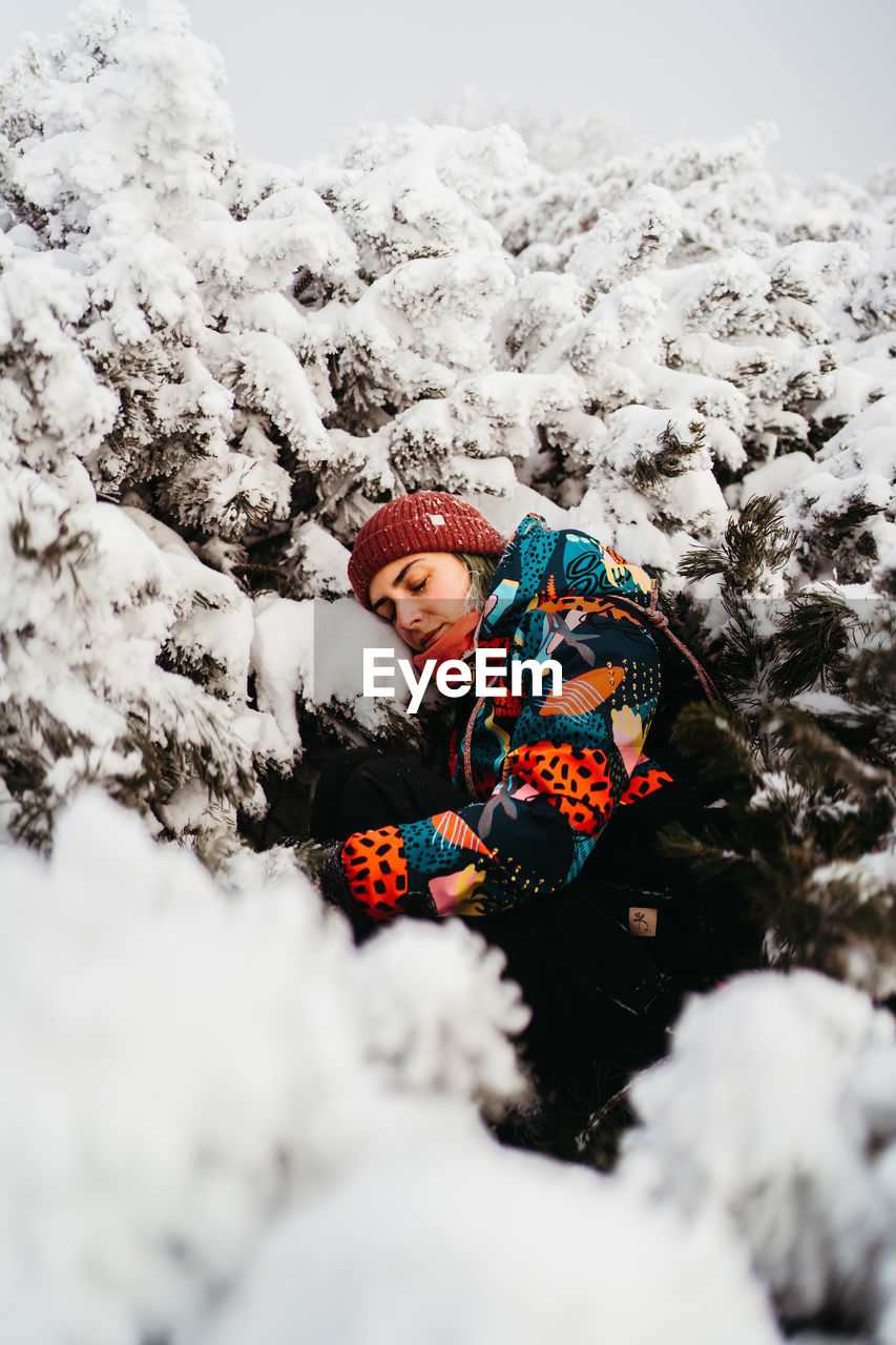 side view of woman sitting on snow