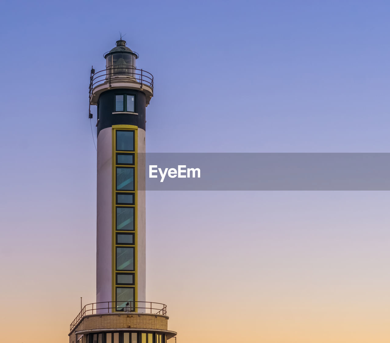 LOW ANGLE VIEW OF LIGHTHOUSE AGAINST BUILDING AGAINST CLEAR SKY