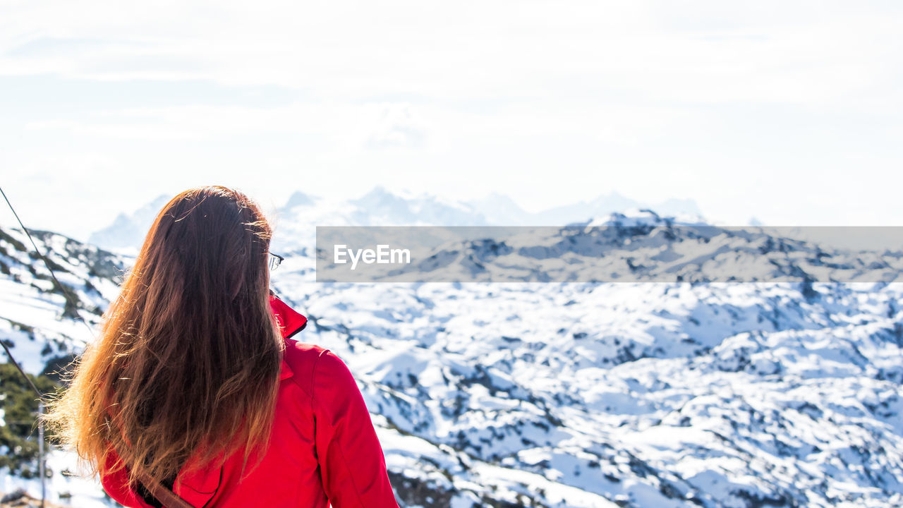 Rear view of woman in front of snow covered mountain