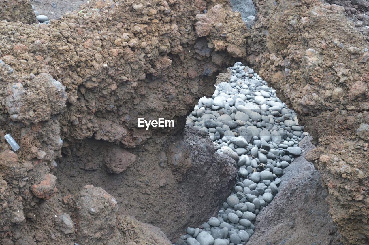 High angle view of pebbles seen through natural arch