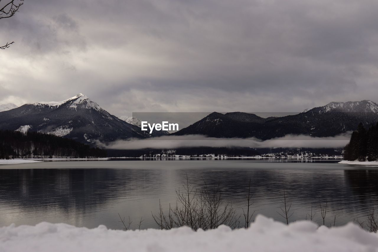 Scenic view of lake and snowcapped mountains against sky