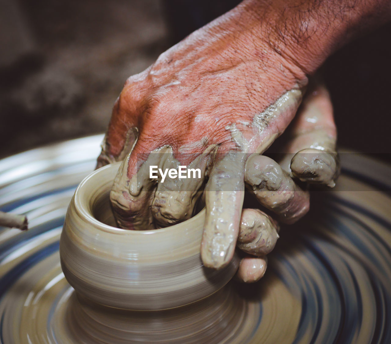 Cropped hand of person working with earthenware