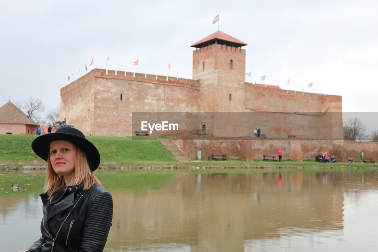 Portrait of beautiful woman against historical building