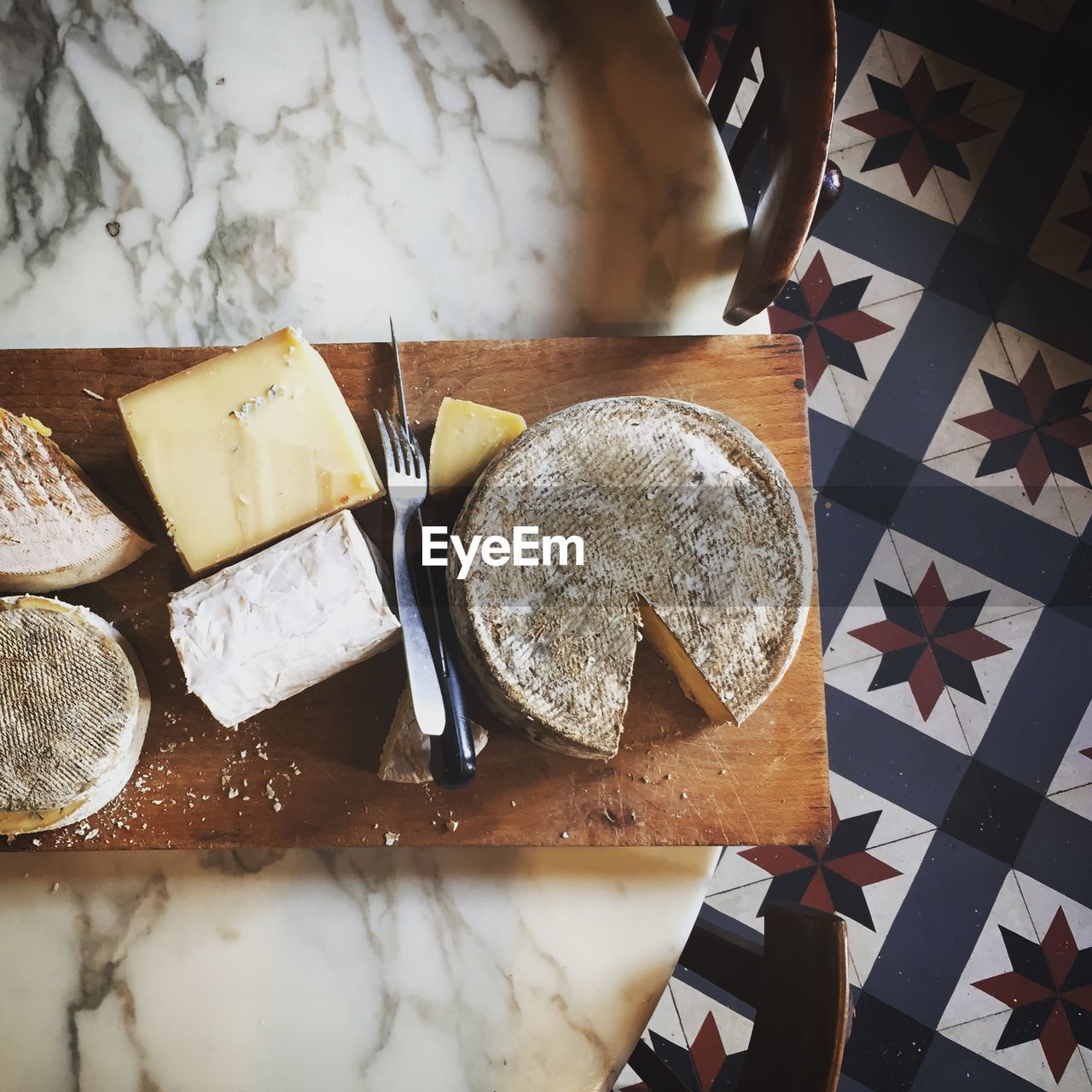 Directly above shot of cheese on cutting board at table