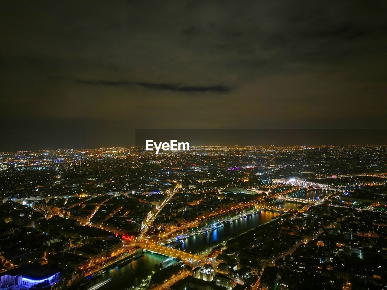 Illuminated cityscape against sky at night
