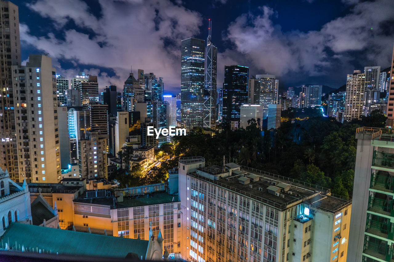 illuminated buildings in city against sky at night