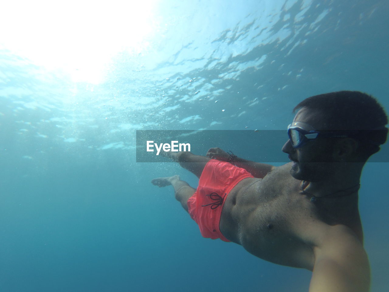 SHIRTLESS MAN SWIMMING IN SEA