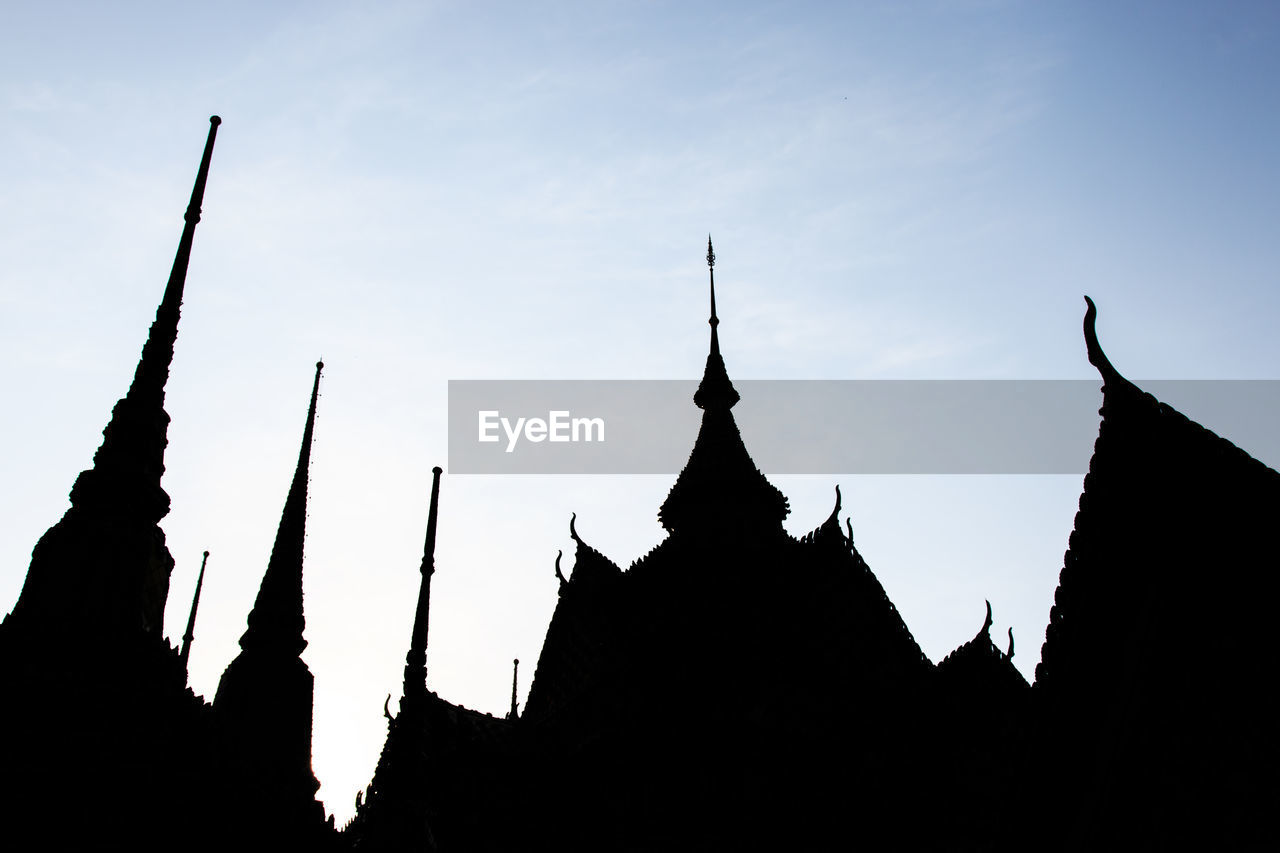 Low angle view of silhouetted roof of temples at dusk