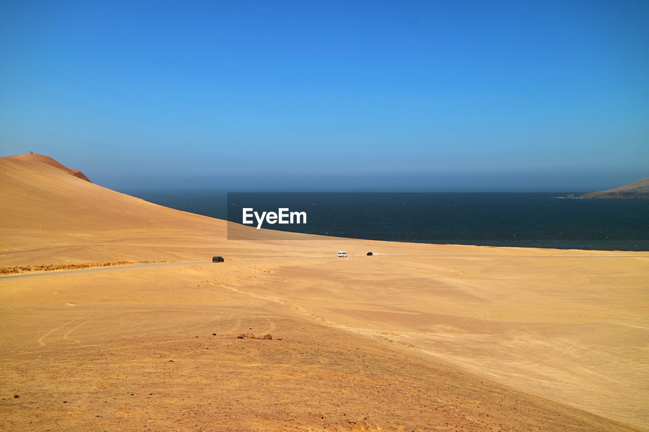 The vast sand dunes of paracas national reserve with pacific ocean in the backdrop, ica region, peru