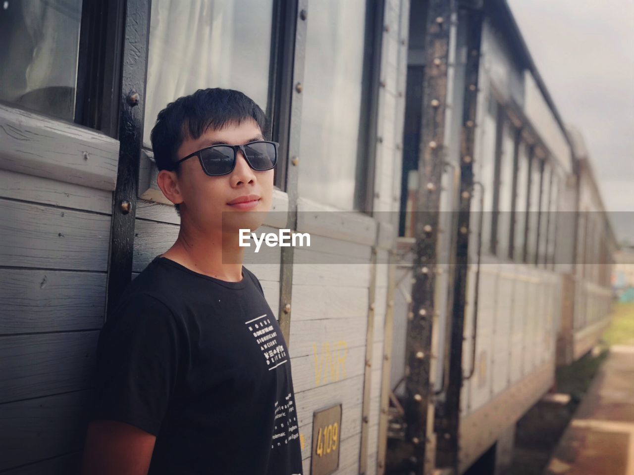 Portrait of young man standing by train